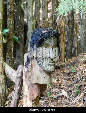 Geschnitzte Māori-Kopf mit traditionellen Tätowierungen an Mitai Maori Dorf, Rotrua, Neuseeland. Stockfoto