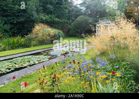Die wunderbare Wirkung von Gräsern in einem Garten mit Teich Stockfoto