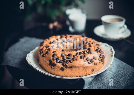 Nahaufnahme, Kuchen mit Schokolade und Kaffee oder Kakao auf dem Schwarzen Tisch. Gemütliche Atmosphäre zu Hause. Wochenende morgens in Noir im nordischen Stil. Hygge conce Stockfoto