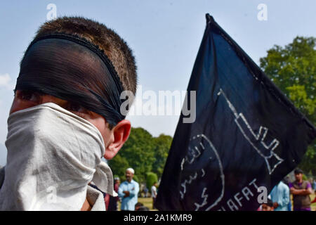 Eine maskierte Kind auf während des Protestes aussieht. eine Rallye wurde in Srinagar Stadt bald nach dem Freitagsgebet folgende die Verschrottung von Artikel 370 durch die zentrale Regierung, die besonderen Status in Jammu und Kaschmir Zuschüsse statt. Stockfoto