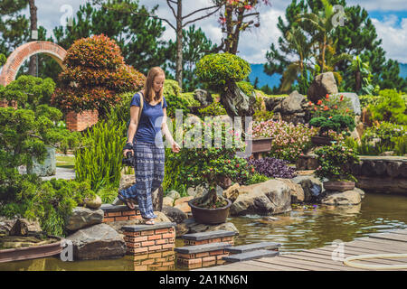 Eine junge Frau geht über den Fluss auf den Felsen Stockfoto