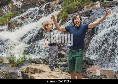 Vater und Sohn im Hintergrund des wunderschönen, kaskadierenden Datanla-Wasserfalls in der Bergstadt Dalat, Vietnam Stockfoto