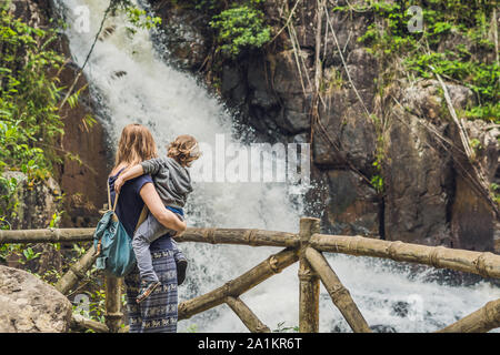 Mutter und Sohn im Hintergrund des wunderschönen, kaskadierenden Datanla-Wasserfalls in der Bergstadt Dalat, Vietnam Stockfoto