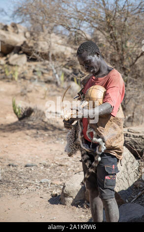 Lake Eyasi, Tansania, 11. September 2019: hadzabe Mann herausgegriffen und spielt handgemachte Musikinstrument Stockfoto