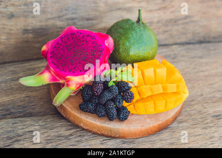 Geschnittene Drachenfrucht und Mango auf einem alten Holzhintergrund Stockfoto