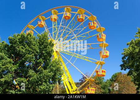 Riesenrad gegen den blauen Himmel Hintergrund auf der Strandpromenade. Attraktionen und Unterhaltung während der Feiertage. Ferienhäuser Konzept. Stockfoto