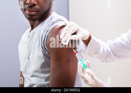 In der Nähe von Doktor injizierender Impfstoff in den Arm Patienten mit Spritze Stockfoto