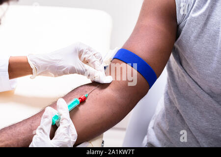 Nahaufnahme der Arzt die Blutprobe von Arm des Patienten Stockfoto