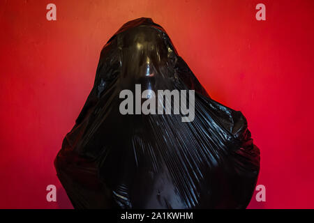 Person in schwarzen Plastiktüte gefangen. Konzept der Horror Movie Szene. Erstickung und Tod. Dunkles Stockfoto. Stockfoto