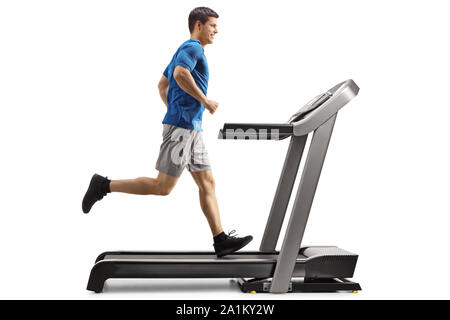 Volle Länge Profil geschossen von einem Kerl, der auf einem Laufband auf weißem Hintergrund Stockfoto