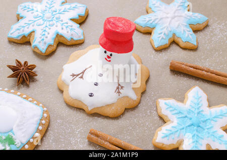 Backen für Weihnachten Lebkuchen wie schmelzender Schneemann, Schneeflocken und Mehl wie Schnee auf dem Backpapier Stockfoto