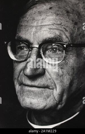 Feine schwarze und weiße Kunst Fotografie von den 1970er Jahren Portrait eines älteren Römisch-katholischen Priester tragen Brille. Stockfoto