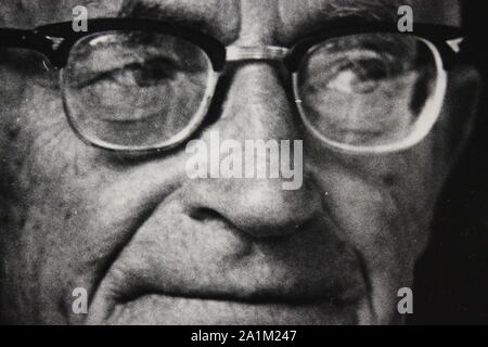 Feine schwarze und weiße Kunst Fotografie von den 1970er Jahren Portrait eines älteren Römisch-katholischen Priester tragen Brille. Stockfoto