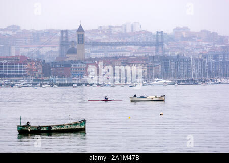 Boote an der Mündung des Nervion River mit der Ansicht von Getxo und Portugalete und der Regionalregierung der Provinz Vizcaya Brücke,, Vizcaya, Baskenland, Spanien. Stockfoto