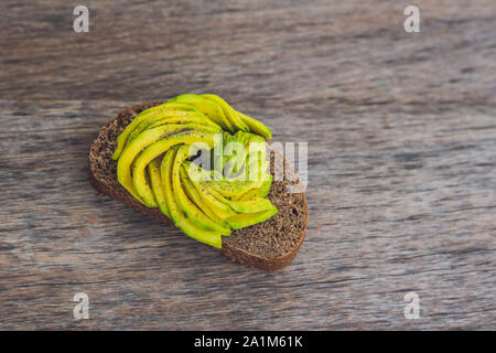 Avocado-Sandwich auf Schwarzbrot mit frisch geschnittenen Avocados gemacht Stockfoto