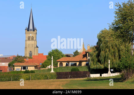 Die Wytschaete Soldatenfriedhof mit Celtic Cross 16 (Irisch) Abteilung und der Heilige Medardus Kirche (1925) Wijtschate, Belgien Stockfoto