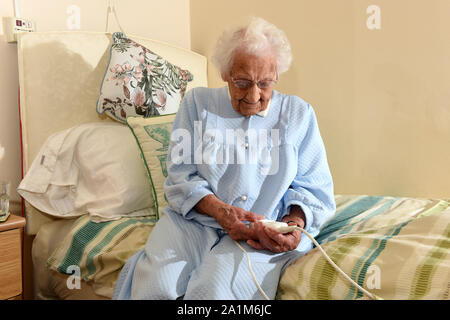 Ältere Dame zu Bett gehen mit einer Heizdecke Großbritannien Großbritannien Stockfoto