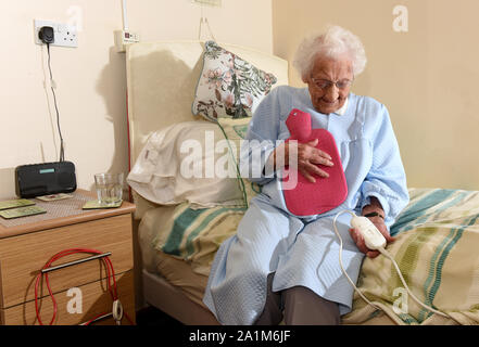 Ältere Dame zu Bett gehen mit einer Heizdecke und Wärmflasche Großbritannien Großbritannien Stockfoto