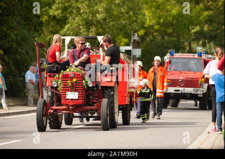 Deutschland, Niederstetten, Baden Württemberg. September 2019. Traditionelle herbstliche Ernte Fest. Eingerichteten historischen Traktor Mc Cormick und Feuerwehrmänner Stockfoto