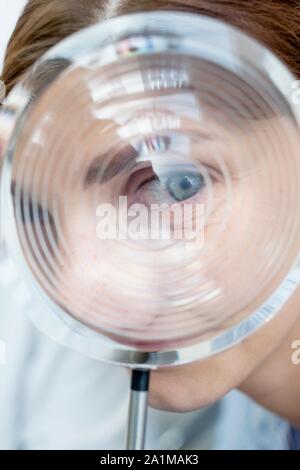 Modell ophthalmologische Objektiv. Frau Suchen durch ein Modell objektiv. Stockfoto