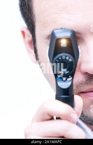 Auge Prüfung. Augenarzt durch einen Ophthalmoscope, Auge des Patienten zu untersuchen. Stockfoto