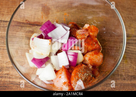 Vorbereitung der hähnchenspieße mit Gemüse. Hähnchenfleisch in Schüssel mit Zwiebel, Paprika, gehackt, Marinade Stockfoto