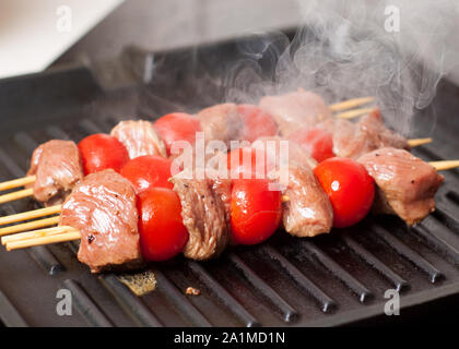 Vorbereitung der Balsamico steak Spieße mit Kirschtomaten auf Grillpfanne Stockfoto
