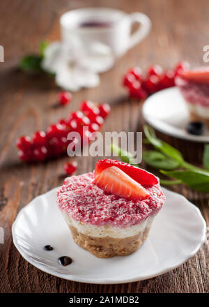 Raw vegan Käsekuchen mit Erdbeere und Banane auf hölzernen Tisch Stockfoto