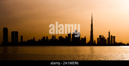 Atemberaubender Blick auf die Silhouette der Skyline von Dubai während eines schönen und dramatischen Sonnenuntergang. Dubai ist die größte und bevölkerungsreichste Stadt in den VEREINIGTEN ARABISCHEN EMIRATEN. Stockfoto