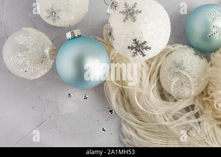 Selektiver Fokus Straußenfedern und funkelnden Christmas Ball Ornamente in weißen und hellen Aqua auf Putz Hintergrund für das Konzept der Engel Flügel und die Stockfoto