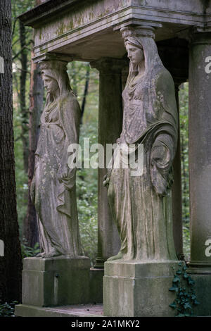 Stein Statue einer trauernden Frau als Dekoration auf einem schattigen Friedhof im Wald Stockfoto