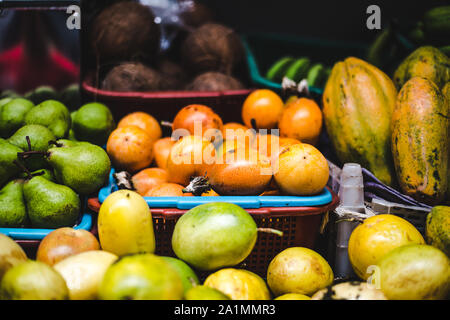 Körbe von exotischen kolumbianischen Früchte zum Verkauf an ein Lebensmittel Marktstand | Juicy granadilla Passionsfrucht, curuba, Guanabana, Kokosnüsse, Birnen und lulo Stockfoto