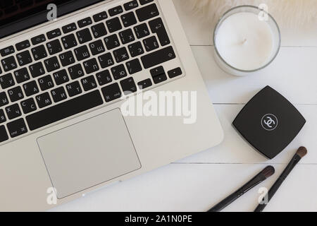 Apple Macbook Pro Retina auf einem Schreibtisch, Tisch mit Kerze und Make-up-Sachen. Mock-up für Aufkleber, Aufkleber design Stockfoto