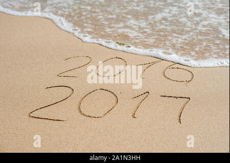 Neues Jahr 2017 kommt Konzept - Inschrift 2016 und 2017 auf einem Strand Sand, die Welle ist fast die Ziffern 2016 Stockfoto