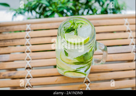 Mojito in einem Glas auf einem Bambustisch. Minze, Limetteneis Stockfoto