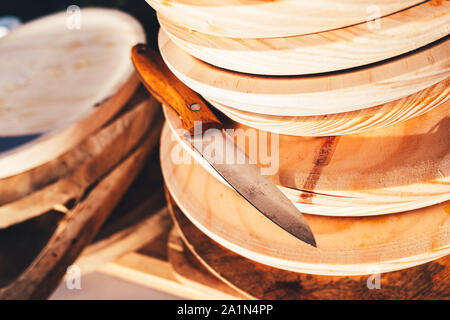 Stapel der schmutzigen Holz- Platten neben einem Taschenmesser nach einem Bankett. Stockfoto