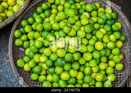 Limetten im Korbkorb auf dem vietnamesischen Markt Stockfoto