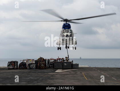 190926-N-EZ 002-1006 INDISCHER OZEAN (Sept. 26, 2019) US Marine Corps Lance Cpl. Payton Stoner, aus Shelbina, Mo, misst der Ladung zu einem militärischen Sealift Command SA-330 J Puma Hubschrauber während einer vertikalen Auffüllung-auf-See auf dem Flugdeck des Amphibious Assault ship USS Boxer (LHD4). Der Boxer Amphibious Ready Group (ARG) und 11 Marine Expeditionary Unit (MEU) werden in den USA 7 Flotte Bereich im Einsatz der regionalen Stabilität zu unterstützen, Partner und Verbündete zu beruhigen, und einer Präsenz zu einer Krise, die von der humanitären Hilfe Blindbewerbungen zu reagieren pflegen. Stockfoto