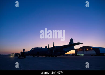 Die Sonne über einen flightline von C-130H Hercules in den frühen Morgen an der 179th Airlift Wing, Mansfield, Ohio, als Betreuer das Flugzeug für den täglichen Betrieb vorbereiten, Sept. 25, 2019. Die 179Th AIrlift Wing ist immer auf einer Mission, die erste Wahl zu sein, der Zustand und die Missionen mit einem vertrauenswürdigen Mannschaft der Flieger zu reagieren. (U.S. Air National Guard Foto von Tech. Sgt. Joe Harwood) Stockfoto