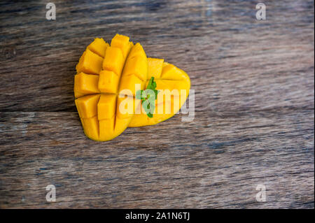 Mango-Frucht und Mango Würfel auf dem Holztisch. Stockfoto