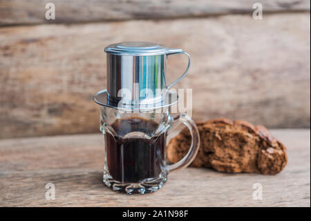 'Phin' traditionelle vietnamesische Kaffeemaschine, auf das Glas legen, gemahlenen Kaffee hinzufügen, dann heißes Wasser gießen und warten, bis der Kaffee hineintropft Stockfoto