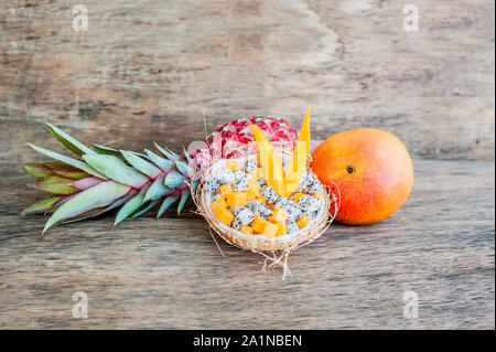 Obstsalat mit Drachenfrucht und Papaya in einer halben Kokosnuss Stockfoto