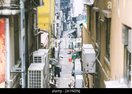 Gasse in Hongkong unter hohen Gebäuden. Stockfoto