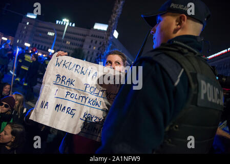 Ein Aktivist aus dem Aussterben Rebellion Organisation hält ein Plakat während der Polizist missmutig während des Protestes. Demonstranten auf die Strasse auf der ganzen Welt für eine weitere Runde des globalen Klimawandels Streiks und in Warschau tausende Bürger nahmen an einem Marsch für das Klima der Erde - eine unabhängige, Gras organisiert - Wurzeln Bürgerbewegung, die gegründet wurde, um zu helfen, den Klimawandel, während eine Gruppe von Aktivisten vor dem Aussterben Rebellion Organisation nach der Klima März die größte Schnittmenge von Warschau blockiert abhalten. Einige Aktivisten ein Globus geformten Zelt in eine Spur der Stockfoto