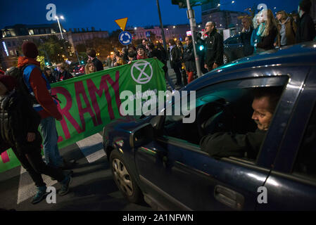 Aktivist aus dem Aussterben Rebellion Organisation halten ein Banner beim Blockieren den Verkehr auf der Straße während des Protestes. Demonstranten auf den Straßen in der ganzen Welt für eine weitere Runde des globalen Klimawandels Streiks und in Warschau tausende Bürger hit nahmen an einem Marsch für das Klima der Erde - eine unabhängige, Gras organisiert - Wurzeln Bürgerbewegung, die gegründet wurde, um zu helfen, den Klimawandel, während eine Gruppe von Aktivisten vor dem Aussterben Rebellion Organisation nach der Klima März die größte Schnittmenge von Warschau blockiert abhalten. Einige Aktivisten ein Globus geformten Zelt in eine Spur von Stockfoto