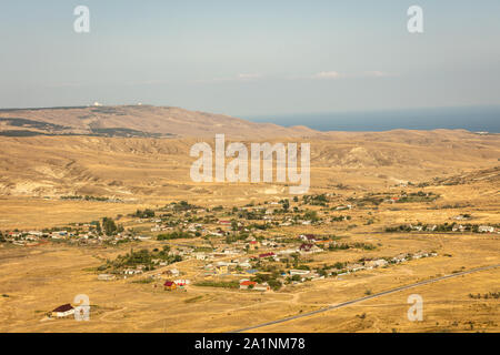 Panoramablick auf die Berge, die Landschaft, das Meer und das Dorf von dem Berg an einem sonnigen Sommertag. Russland, Krim Stockfoto