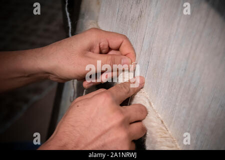 Ein Afghanistan Wolldecke Teekocher arbeitet auf eine Wolldecke auf einem traditionellen Webstuhl Stockfoto