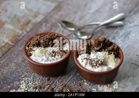 Gesundes Frühstück mit weißen Joghurt, Chia, Samen und Schokolade Müsli. Fitness Frühstück. Vegetarisches Essen. Keto Diät. Selektive konzentrieren. Makro. Stockfoto