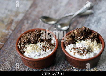 Gesundes Frühstück mit weißen Joghurt, Chia, Samen und Schokolade Müsli. Fitness Frühstück. Vegetarisches Essen. Keto Diät. Selektive konzentrieren. Makro. Stockfoto