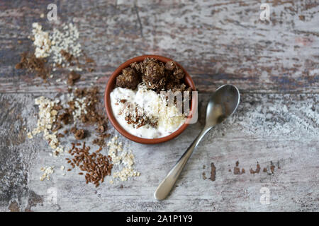 Gesundes Frühstück mit weißen Joghurt, Chia, Samen und Schokolade Müsli. Fitness Frühstück. Vegetarisches Essen. Keto Diät. Selektive konzentrieren. Makro. Stockfoto